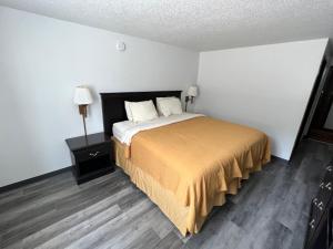 una camera da letto con un grande letto con copriletto giallo di Dickinson Inn a Dickinson
