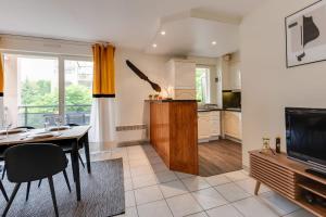 a kitchen and dining room with a table and a television at The Parc des Raisses - T2 for 4 people in Annecy