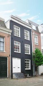 une maison noire avec des portes de garage blanches dans une rue dans l'établissement Dahli's Sleep Boutique, à Amsterdam