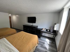 a hotel room with two beds and a flat screen tv at Dickinson Inn in Dickinson