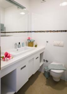 a white bathroom with a sink and a toilet at Lavica Bellevue apartments & studios in Podstrana