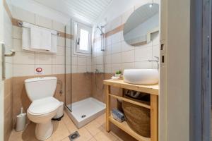 La salle de bains est pourvue de toilettes, d'un lavabo et d'une douche. dans l'établissement Helen's Studios & Apartments, à Skála Kefalonias