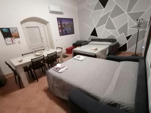a room with two beds and a table and a dining room at Zeropassidalcentro Zeroinfrominthecenter in Marsala