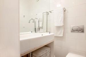 a white bathroom with a sink and a mirror at Dahli's Sleep Boutique in Amsterdam +15 photos