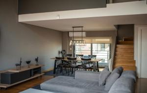 a living room with a couch and a dining room at Minimal Brand New Loft next to Subway in Athens