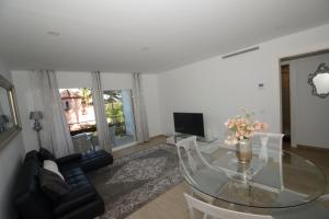 マルベーリャにあるPenthouse Marbellaのガラスのテーブルと椅子のあるリビングルーム