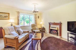 a living room with a couch and a tv at Berries in Barningham