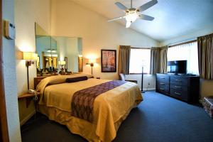 a hotel room with a bed and a ceiling fan at Snow Lake Lodge in Big Bear Lake