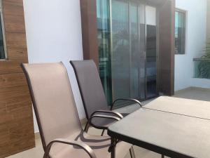 a dining room with a table and four chairs at Cancún Airport Zone in Cancún