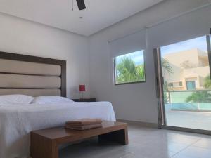 a bedroom with a bed and a table and a window at Cancún Airport Zone in Cancún