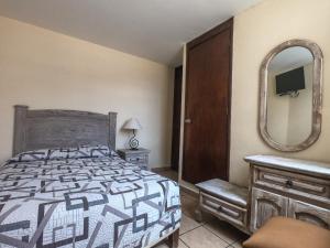 una camera da letto con un letto, uno specchio e una cassettiera di Posada del Carmen a Zacatecas