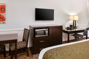 a hotel room with a bed and a desk and a television at Glendale Hotel in Glendale