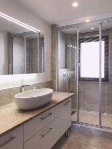 La salle de bains est pourvue d'un grand lavabo blanc et d'une douche. dans l'établissement Große Wohnung mit 2 Schlafzimmern, à Altensteig