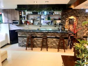 a bar in a kitchen with a brick wall at Hidden Garden in Cusco