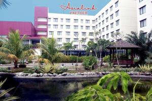 a hotel with a pond in front of a building at Asialink Premier hotel in Karawang