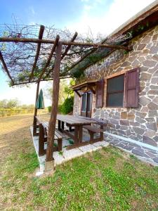 uma mesa de piquenique em frente a um edifício de pedra em Agriturismo “Sterrati” em Valpiana