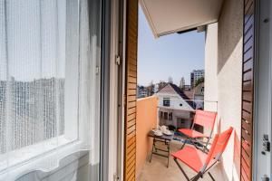 einen Balkon mit einem Tisch und Stühlen sowie einem Fenster in der Unterkunft The Bells - Charming T2 near the Lake in Annecy