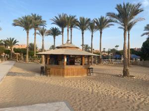 a gazebo on a beach with palm trees at Private chalte Palmera sokhna family in Ain Sokhna