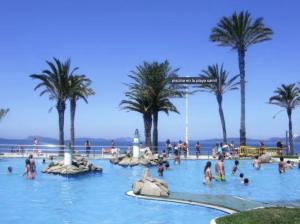 una piscina en la playa con gente en el agua en Samil Apartment, primera línea de playa con Wifi y Garaje, en Vigo