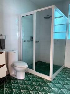 een badkamer met een toilet en een glazen douche bij 2D TU CASA EN CENTRO CDMX BONITO in Mexico-Stad