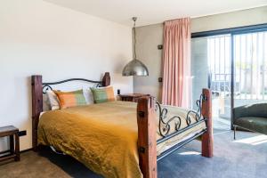 Un dormitorio con una cama grande y un sofá. en Hukamanu Lodge, en Wanaka