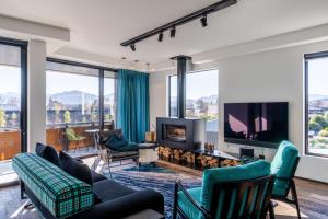a living room with a couch and chairs and a tv at Hukamanu Lodge in Wanaka