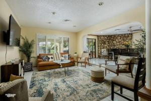 a living room filled with furniture and a stone wall at Cozy Hygge Home Centrally Located 2 King Beds in Bakersfield