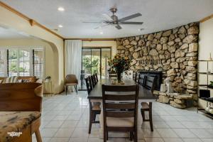 a living room with a stone fireplace and a table and chairs at Cozy Hygge Home Centrally Located 2 King Beds in Bakersfield