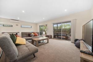 a living room with a couch and a television at Coastal Cootamundra in Capel Sound