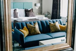 a mirror reflecting a blue couch in front of a bed at The Portland in Ashington +37 photos