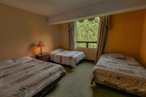 a bedroom with two beds and a window at Torres de Atitlán Pent-House 10 personas - Apartamento 8 personas in Panajachel