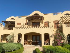 a large building with tables and chairs in front of it at Sabina 2br penthouse in Hurghada