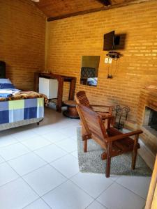 Zimmer mit einem Bett, einem Stuhl und einem Kamin in der Unterkunft Sitio Pousada Morada do Sol in Cunha
