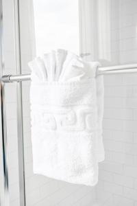 a bunch of white towels on a towel rack in a shower at Metro Points Hotel Washington North in New Carrollton