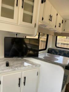 an interior view of an rv kitchen with white cabinets at RV2 Stunning RV Private Netflix FreeParking in Moreno Valley