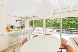 a kitchen and dining room with a white table and chairs at White Sandstone in Amagansett