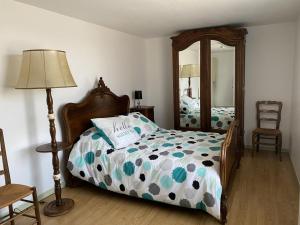 a bedroom with a bed and a lamp and a mirror at Gîte Montaiguët-en-Forez, 5 pièces, 8 personnes - FR-1-489-371 in Montaigüet-en-Forez