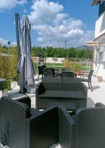 a patio with chairs and an umbrella and an umbrella at B&B Desea in Poggiomarino