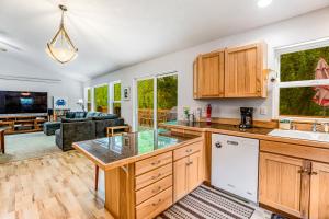 a kitchen with wooden cabinets and a living room at Netarts Getaway in Tillamook