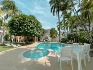a swimming pool with chairs and trees and a house at L`aurora Hotel Boutique in Yopal