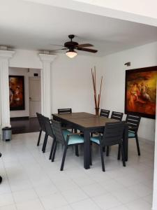 a dining room table with chairs and a ceiling fan at L`aurora Hotel Boutique in Yopal