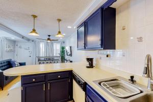 a kitchen with blue cabinets and a sink at The Quarterdeck OC in Ocean City