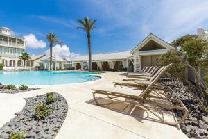 a swimming pool with lounge chairs next to a house at Beaches and Bunkers in Port Aransas