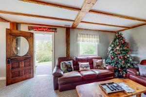 a living room with a christmas tree and a leather couch at Town Farm Retreat in Ludlow