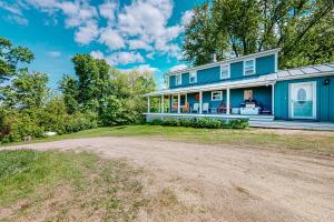 a blue house with a dirt road in front of it at Town Farm Retreat in Ludlow