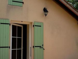 NeuvyにあるCharmant gîte rénové avec terrasse privative, jardin et parking - Animaux acceptés - FR-1-489-10の緑のシャッターとドアとランプのある家 +4枚の写真