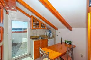 a kitchen with a wooden table and a dining room at Apartments Lucija in Korčula