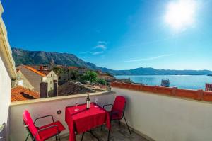 a table and chairs on a balcony with a view of the water at Apartments Lucija in Korčula
