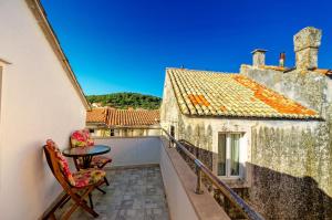 a balcony with a table and chairs on a building at Apartments Lucija in Korčula +7 photos