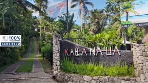 Kaila Na Ua Resort في كوروتوغو: وجود لافته عند مدخل منتجع فيه نخيل